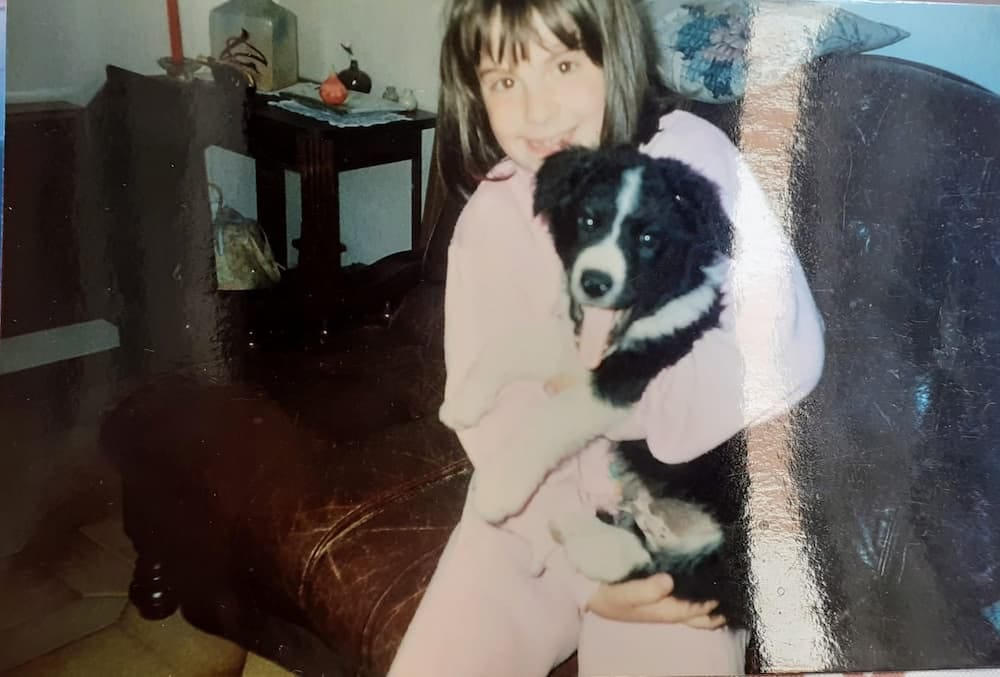 Une enfant souriante tenant un chiot dans ses bras
