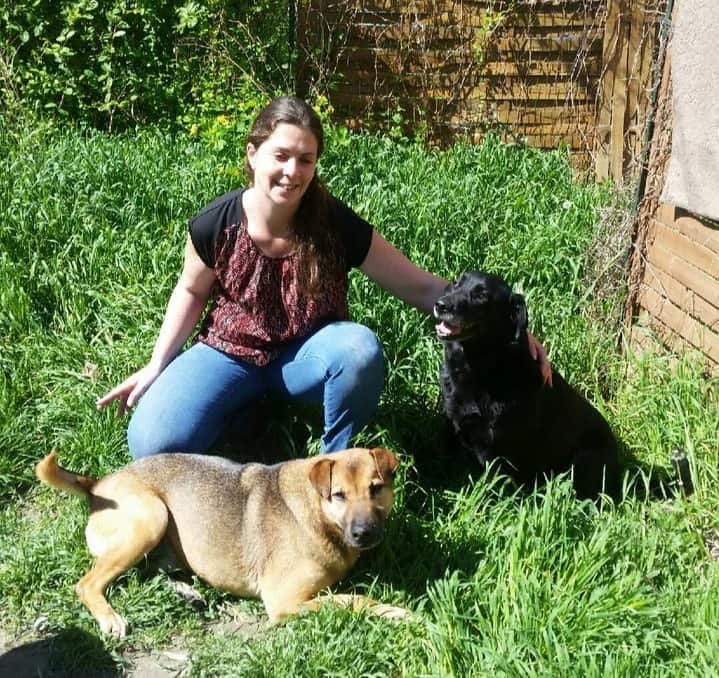 Jeune femme souriante caressant deux chiens